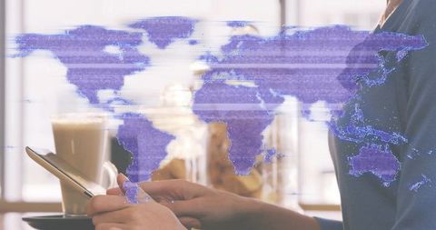 Woman holding smartphone while tapping screen at cafe with purple world map overlay and latte cup