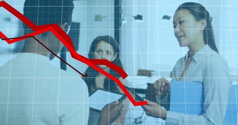 Diverse business team reviewing financial decline graph