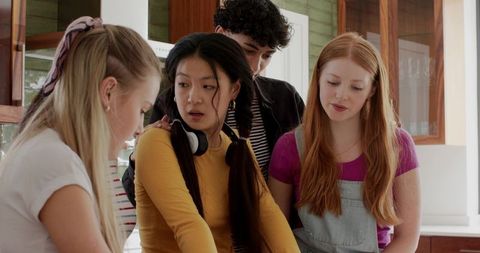 Multicultural Teens Leaning Around Kitchen Counter Inspecting DIY Project