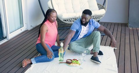 African American Couple Enjoying Balcony Picnic with Wine