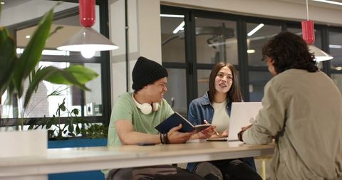 Young African American coworkers collaborating around high table in modern coworking space