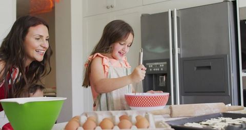 Mother and Daughter Baking Together Whisking Batter Smiling in Bright Family Kitchen