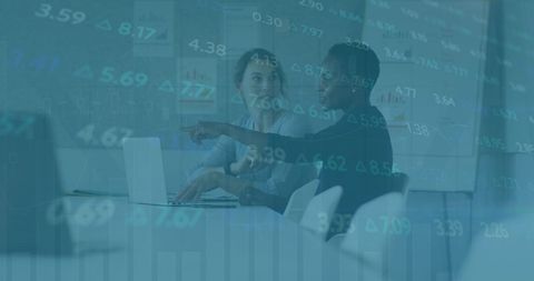 Diverse Female Coworkers Analyzing Financial Data in Office Setting