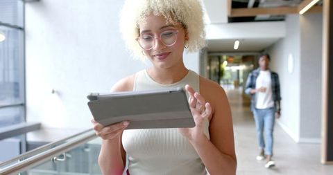 Businesswoman focusing on tablet in contemporary workplace