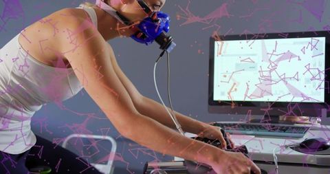 Woman performing vo2 max test on stationary bike with respirator mask and data monitor
