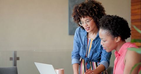Two Women Collaborating at Home with Laptop and Coffee