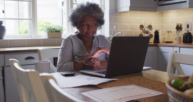 Senior african american woman using laptop and calculating finances at home - Download Free Stock Photos Pikwizard.com