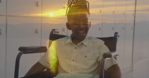 Inspirational schoolboy in wheelchair with sunset overlay