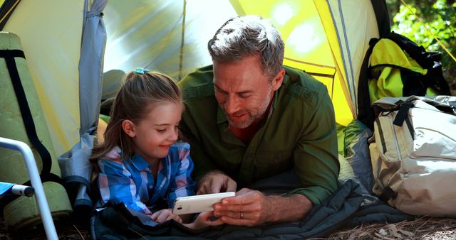 Father and Daughter Enjoying Time Together in Tent Watching Video on Tablet - Download Free Stock Images Pikwizard.com