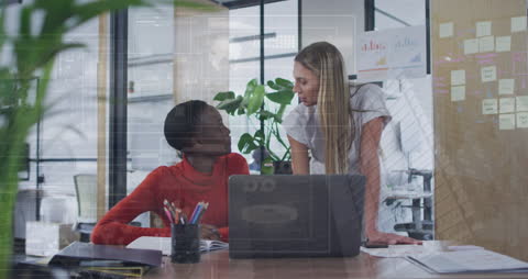 Businesswomen Analyzing Data in Modern Office Setting