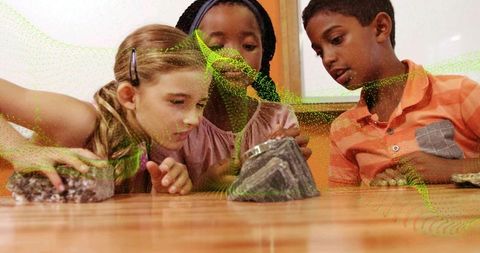 Children examining rock samples in classroom, collaborating on hands-on geology activity