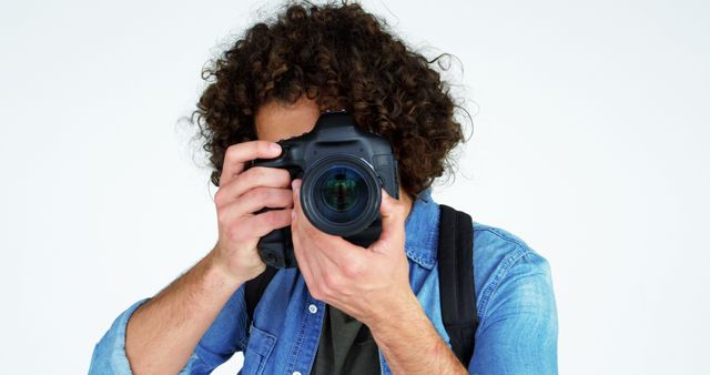 Young Man with Curly Hair Holding Professional Camera - Download Free Stock Images Pikwizard.com