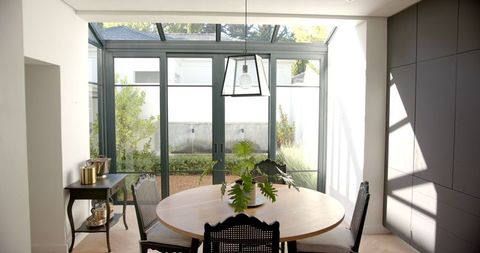 Bright dining room with round table and french windows