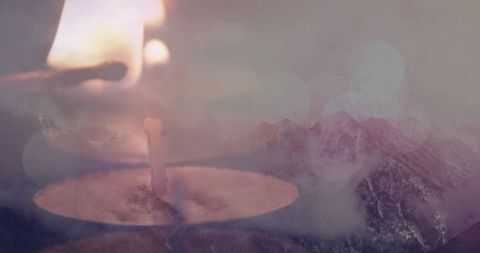 Ethereal tealight flame over misty mountains double exposure dreamy background