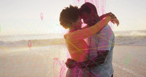 Romantic beach embrace with digital map overlay at sunset