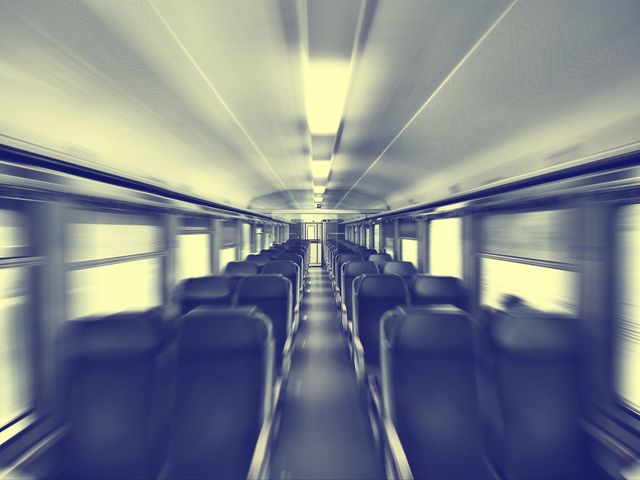 Empty train interior with a focus effect emphasizing motion blur, conveying speed and movement. Ideal for use in travel magazines, transportation advertisements, blog posts about commuting, or articles discussing public transportation efficiency.