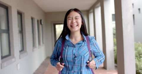 Joyful Teenage Girl in School Corridor with Backpack - Download Free Stock Images Pikwizard.com