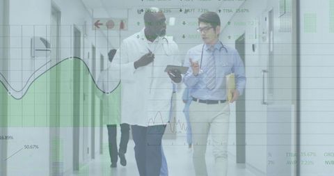 Medical Professionals Analyzing Data in Hospital Corridor for Enhanced Patient Care