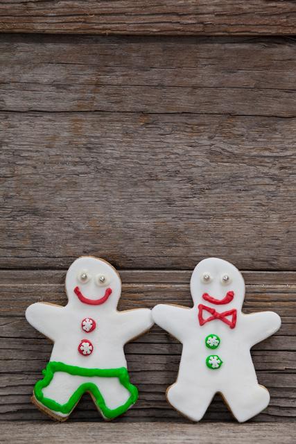 Close-up of two gingerbreads leaning on a plank