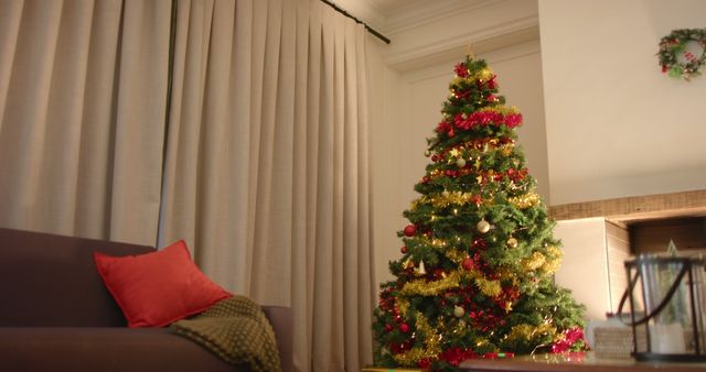 Christmas tree by fireplace in living room with closed curtains at home, copy space, slow motion. Christmas, tradition, celebration, domestic life.