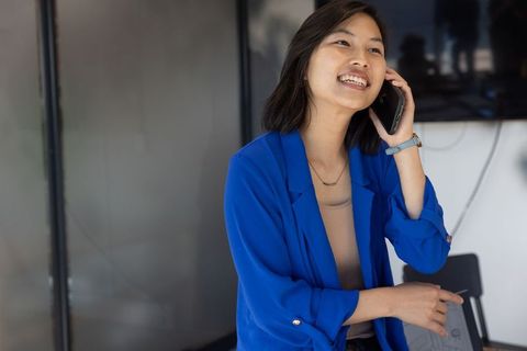 Businesswoman in Bright Blue Blazer Engaging in Phone Conversation