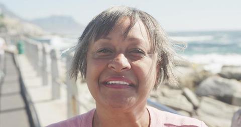 Smiling Elderly Woman Enjoying Sunny Day by Ocean - Download Free Stock Images Pikwizard.com