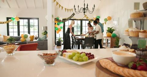 Diverse Friends Setting Up Birthday in Light-Filled Room