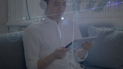 Asian Man Engaging with Digital Network on Tablet