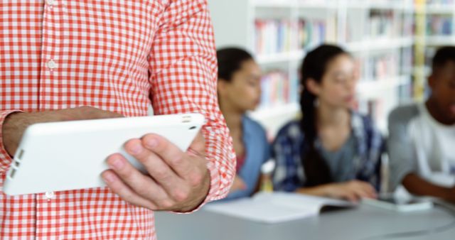 Person Using Digital Tablet in Classroom with Students Studying - Download Free Stock Images Pikwizard.com