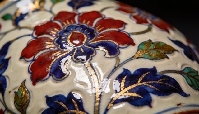 Handpainted cloisonne porcelain with red and blue floral motif and gold gilding