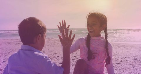 Siblings High-Fiving at Sunset Beach in Celebration