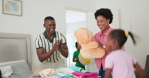 Happy family packing clothes for exciting vacation trip together