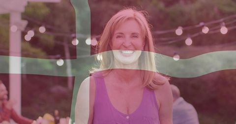 Joyful woman enjoying outdoor evening gathering with lights