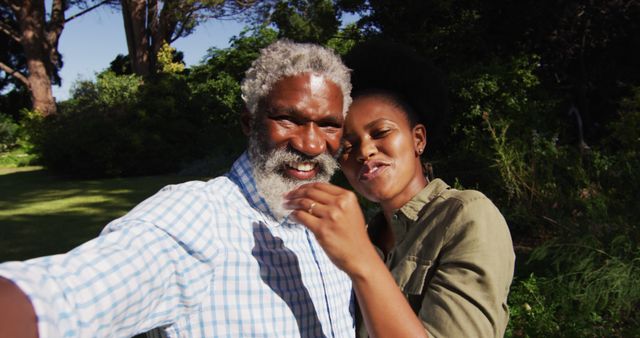 Smiling african american senior couple posing for selfie in sunny garden. staying at home in isolation during quarantine lockdown.