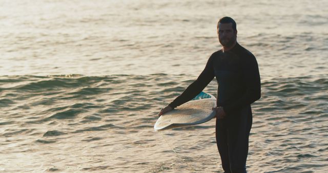 Male Surfer Standing with Surfboard in Sunset Waves - Download Free Stock Images Pikwizard.com