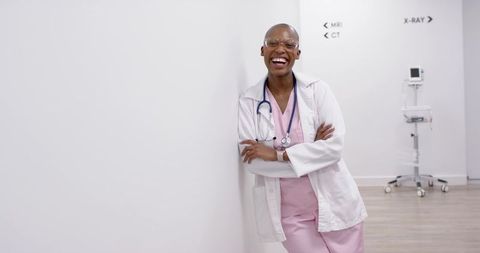 Confident african american physician leaning smiling in radiology corridor