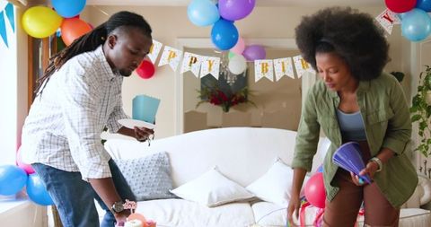 Family Cleaning After Birthday Celebration in Decorated Home