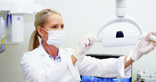Female dentist adjusting dental light in dental clinic 4k