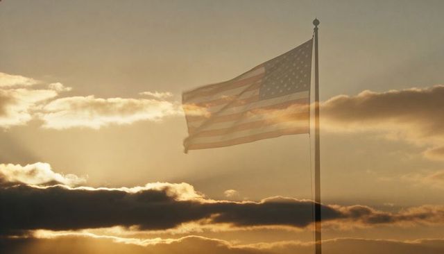 American flag waving at golden sunset with motion blur and layered dramatic clouds