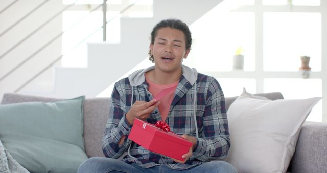 Excited Man Receiving Gift on Couch in Bright Modern Room - Download Free Stock Images Pikwizard.com