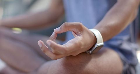 African american man meditating outdoors wearing smartwatch and holding gyan mudra