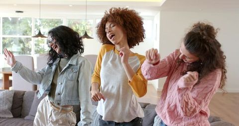 Sunlit Open-Plan Living Room Dance Party with Diverse Women Dancing and Laughing