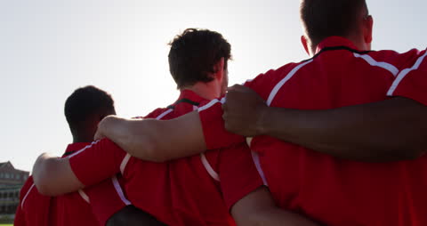 Rugby Players Embracing in Unity on Field