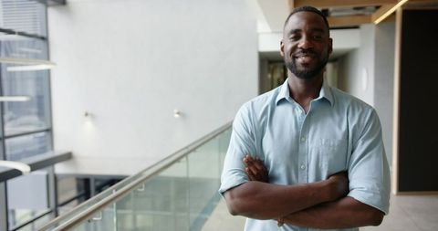 Confident Businessman Standing in Modern Office Hallway