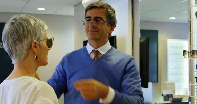 A middle-aged woman receives help from an optician while trying on glasses. - Download Free Stock Photos Pikwizard.com