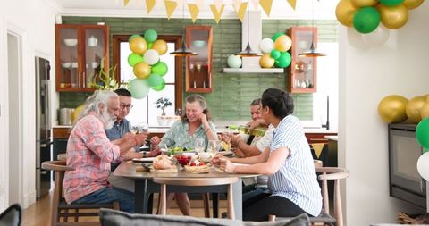Cheerful Friends Celebrating with Wine at Home Gathering