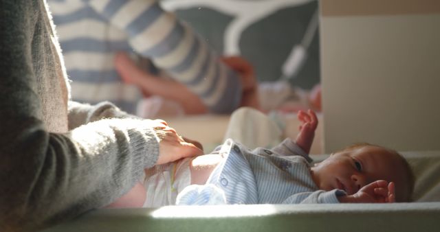 Mother Changing Newborn's Diaper in Sunlit Room - Download Free Stock Images Pikwizard.com