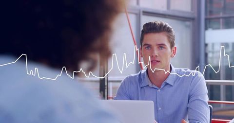 Professional listening during modern office meeting with laptop and waveform overlay