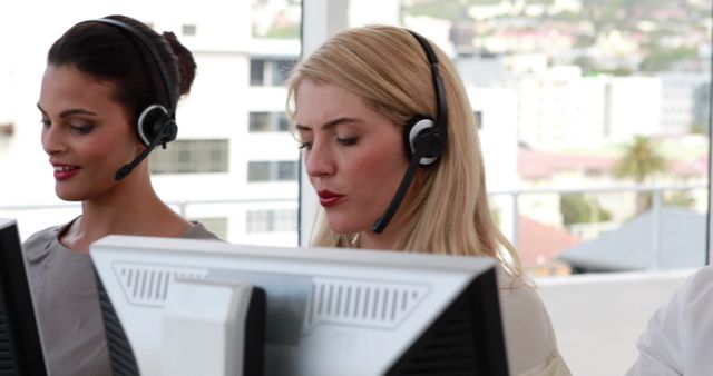 Female call center agents working on computers with headsets - Download Free Stock Images Pikwizard.com