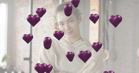 Young woman crossing arms in loft surrounded by floating purple hearts